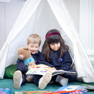 Two young pupils reading a book at the Knightsbridge School private preschool